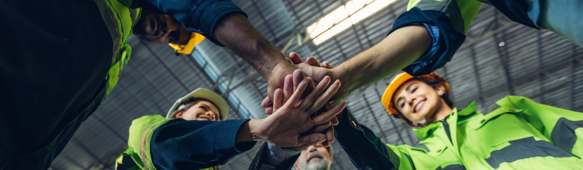Group of successful Worker people showing unity with their hands together. Photo Foreman hands on top as symbol of Teamwork. Teamwork concept.